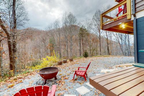 a fire pit and chairs on a porch of a house at Bryson Chalet in Bryson City