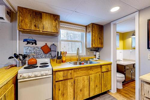 a kitchen with wooden cabinets and a stove and a sink at Bryson Chalet in Bryson City