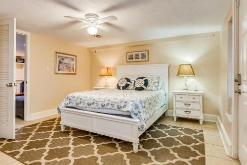 a bedroom with a white bed and two night stands at Nautical Niche-Master in Galveston