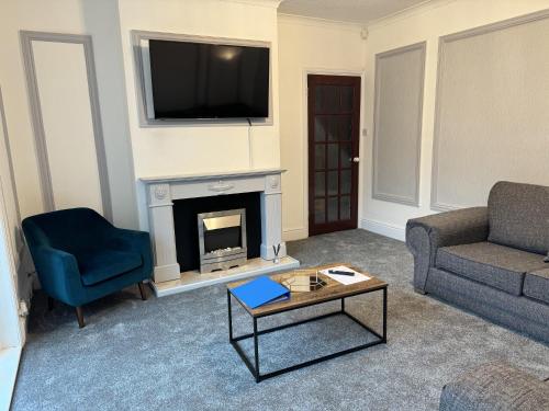a living room with a fireplace with a tv above it at Largee 5 Bed House, Sleeps 10 Near NEC, BHX, HS2 in Birmingham