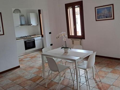 a dining room with a white table and chairs at Ca' Piave in Mestre