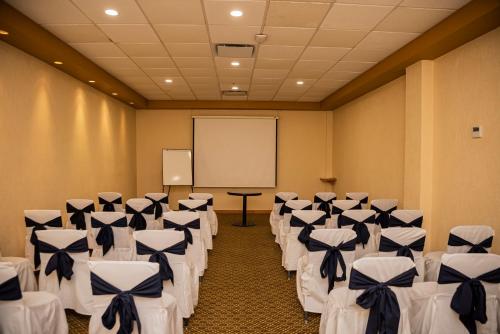 a room with rows of chairs and a screen at Holiday Inn La Piedad by IHG in La Piedad Cavadas