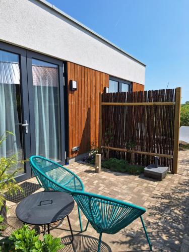 two green chairs and a table in front of a building at Luxury Suites Oosterwold in Almere