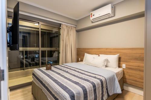 a hotel room with a bed and a window at Apartamentos Studio Allure Moema - Com recepção 24 horas in Sao Paulo