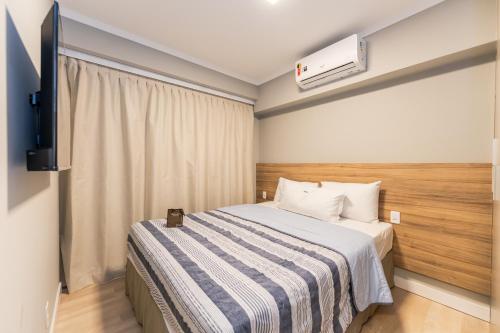 a hotel room with a bed and a tv at Apartamentos Studio Allure Moema - Com recepção 24 horas in São Paulo