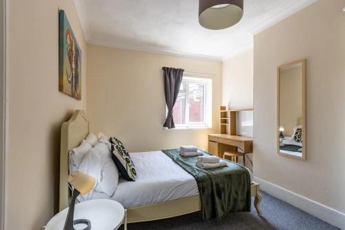 una camera con letto, tavolo e specchio di Wow Look Central 2bed Parking Next To Hospital a Southampton