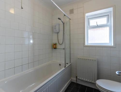 a bathroom with a bath tub and a toilet at Wow Look Central 2bed Parking Next To Hospital in Southampton