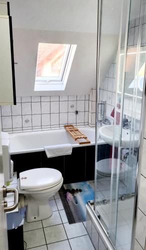 a bathroom with a toilet and a tub and a sink at Monteurwohnung Ha-Wei -90 m2 in Hangen-Weisheim
