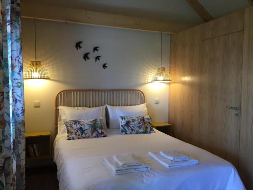 a bedroom with a bed with two towels on it at Chalet Tropical in Arco da Calheta
