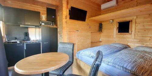 een slaapkamer met een tafel en een bed in een hut bij Holiday Hut in Bornerbroek
