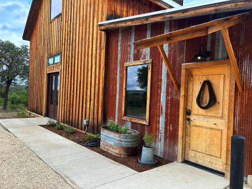 a red barn with a door and plants on it at Inn at Sunset Mill Ranch in Wimberley