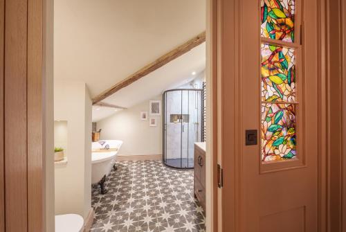 a bathroom with a tub and a stained glass window at Teller’s Secret Loft House - 2 Bedroom Apartment in Central Bristol by Mint Stays in Bristol