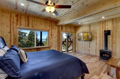 a bedroom with a bed and a fireplace and a ceiling fan at Tall Pine Chalet in Stateline
