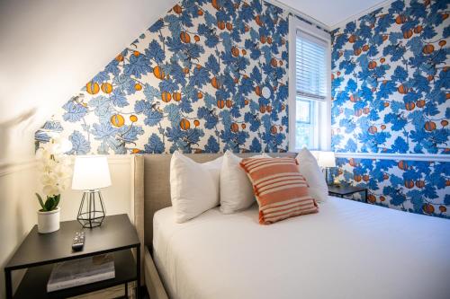 a bedroom with a bed with blue and orange wallpaper at Hearthside Inn in Bar Harbor