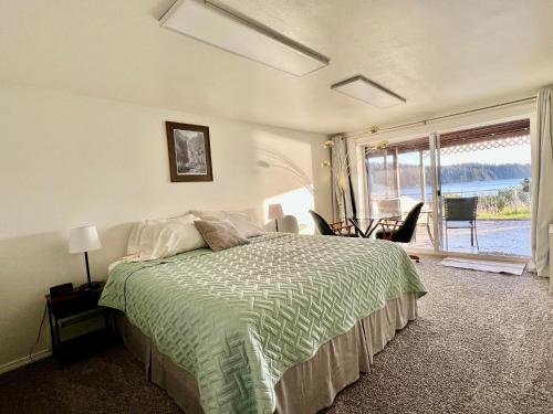 1 dormitorio con cama y ventana grande en The State Room - Cliffside, Ocean Views, en Kodiak