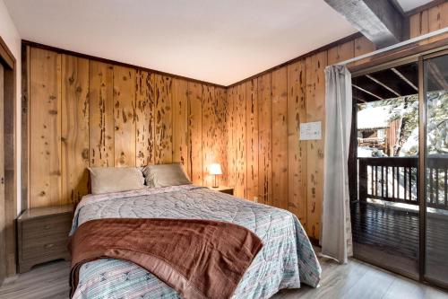 a bedroom with a bed and a wooden wall at Snowflake Chalet in Stateline