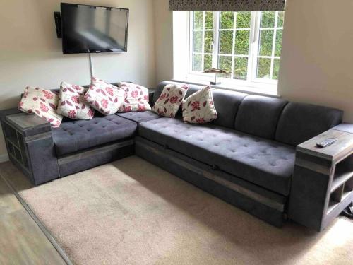 a blue couch with pillows in a living room at Entire guest suite with gated property in Broad Blunsdon