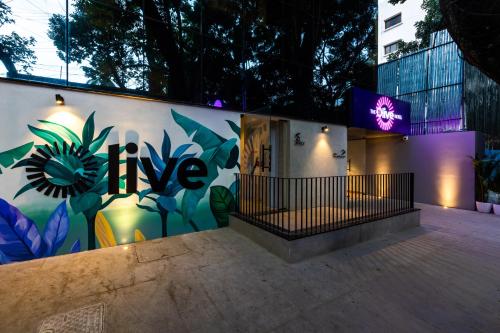 Olive Indiranagar 100ft Road - by Embassy Group في بانغالور: جدار عليه لوحة جدارية من الزهور