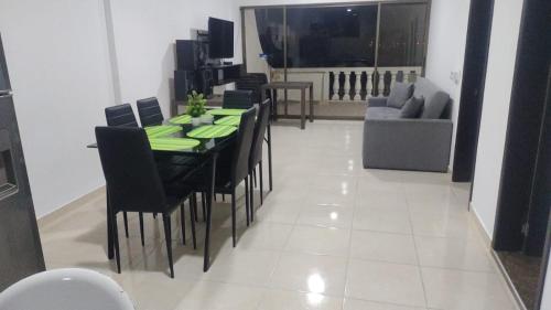 comedor con mesa y sillas negras en lujoso apartamento, en Ricaurte