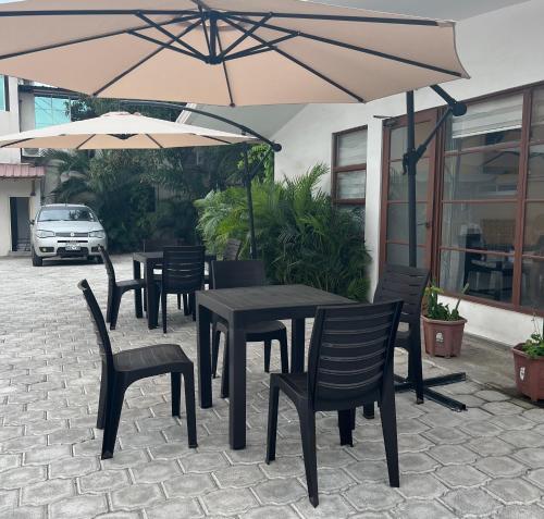 einen Tisch und Stühle mit Sonnenschirmen auf einer Terrasse in der Unterkunft HOTEL PLAYAS PERDERNALES ECUADOR in Pedernales