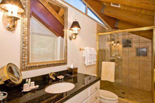 a bathroom with a sink and a shower and a mirror at Downtown Penthouse in South Lake Tahoe