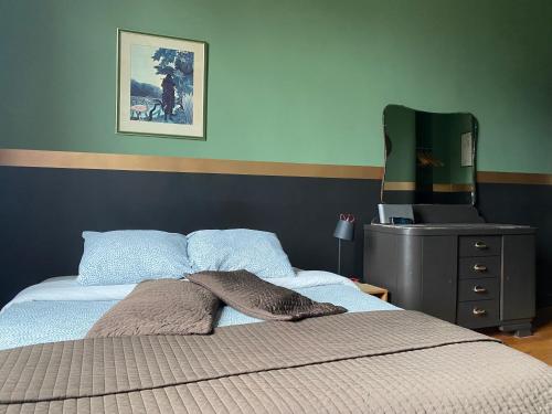 a bedroom with a bed and a dresser with a television at Vakantielogies Faja lobi in Ghent