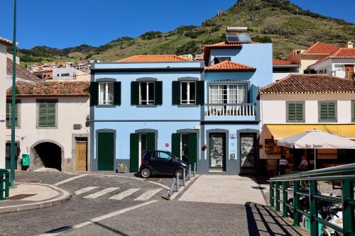 a blue building with a car parked in front of it at Machim House by AnaLodges in Machico