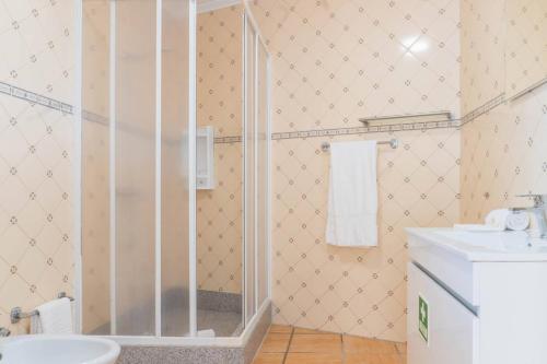 a bathroom with a shower and a toilet and a sink at Mosteiros Natural Pool House in Mosteiros