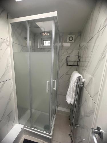 um chuveiro com uma porta de vidro na casa de banho em Experience Downing Road Dagenham 2 bedroom Apartment em Dagenham