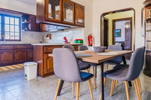 a kitchen with a wooden table and chairs at Sun&Beach Retreat in Ponta Delgada