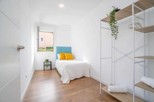 Cette chambre blanche dispose d'un lit et d'une fenêtre. dans l'établissement Jouvacations Villa La Selva, à Vilafant