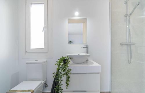 La salle de bains blanche est pourvue d'un lavabo et d'un miroir. dans l'établissement Jouvacations Villa La Selva, à Vilafant