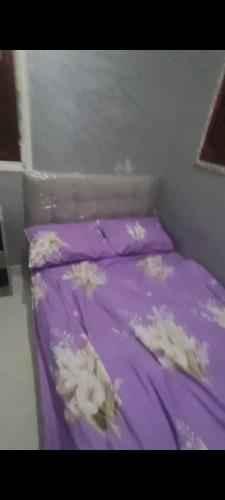 ラバトにあるRabat center studioの紫のシーツと白い花が飾られたベッド