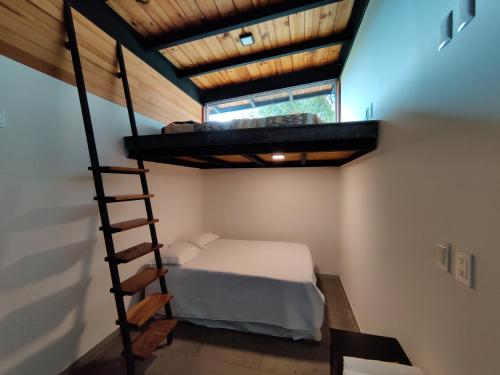 a bedroom with a bunk bed and a ladder at Casa Ilhe Ha in Santa María Tonameca
