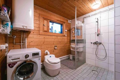 y baño con lavadora y ducha. en Upea hirsi mökki ulkoporeltaalla, en Hämeenlinna
