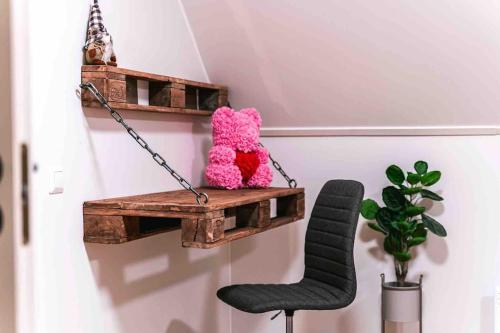 a stuffed teddy bear sitting on a shelf with two chairs at Upea hirsi mökki ulkoporeltaalla sekä kelosaunalla in Hämeenlinna