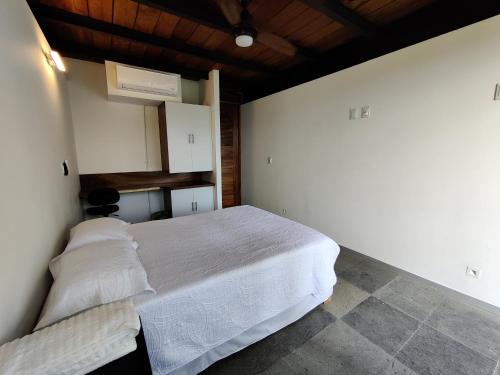 a bedroom with a white bed and a wooden ceiling at Casa Ilhe Ha in Santa María Tonameca