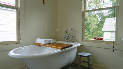 baño con bañera blanca y ventana en The North Branch Inn en North Branch