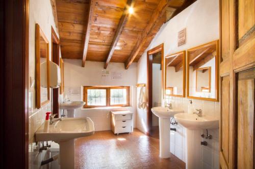a bathroom with two sinks and two mirrors at Acogedor alojamiento rural ideal para grupos in Agres