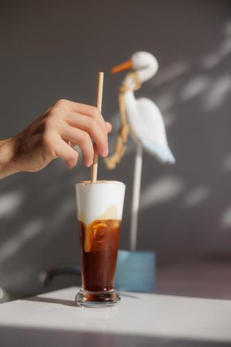a person holding a drink in a cup with aitatingitatingitatingitatingitatingitating at Nafsika Hotel - Adults Only in Dassia