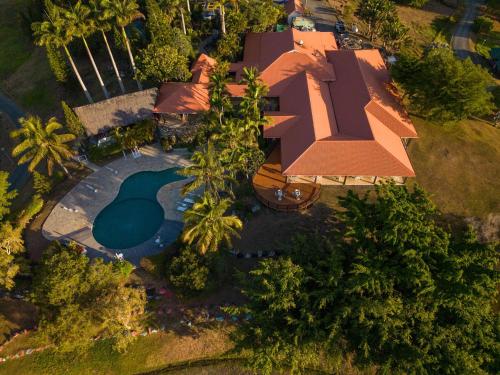 Cette chambre offre une vue sur une maison dotée d'une piscine. dans l'établissement Rivland Resort, à Païta