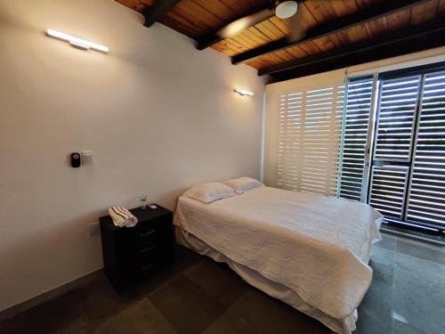 a bedroom with a bed and a large window at Casa Ilhe Ha in Santa María Tonameca