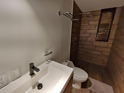 a bathroom with a white sink and a toilet at Casa Ilhe Ha in Santa María Tonameca
