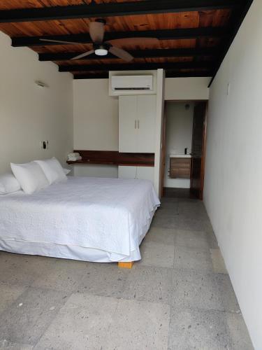 a bedroom with a white bed and a ceiling at Casa Ilhe Ha in Santa María Tonameca