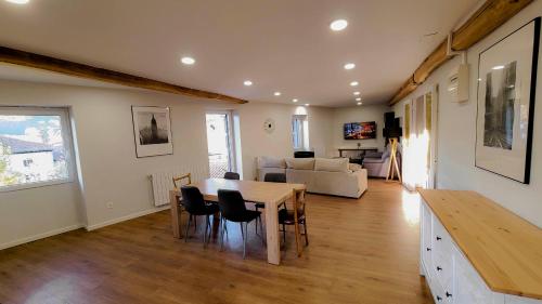 a dining room and living room with a table and chairs at Apartamentos Elizondo Center in Elizondo