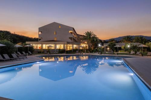 a large pool with blue water in front of a building at Nafsika Hotel - Adults Only in Dassia