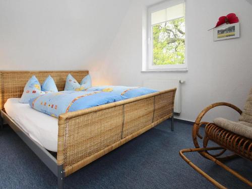 a bedroom with a bed with blue sheets and a window at Cottage on the Kummerower See, Kummerow in Kummerow