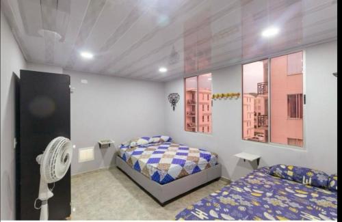 1 dormitorio con 2 camas y ventilador en APARTAMENTO ALQUILER SANTA MARTA, en Santa Marta
