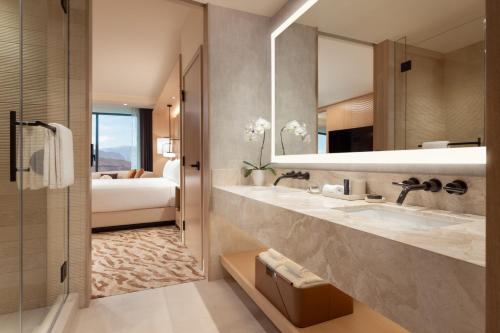 a bathroom with two sinks and a mirror and a bed at Durango Casino & Resort in Las Vegas