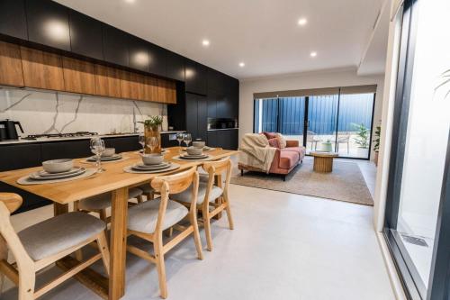 una cucina e un soggiorno con tavolo e sedie in legno di Beautiful 4BR Family home with Patio and Parking! a Perth